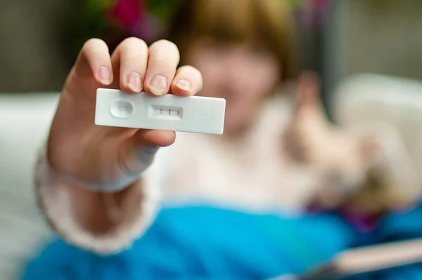 stock image Teenage girl showing antigen self test card with positive result for Coronavirus or Covid-19. Testing at home.