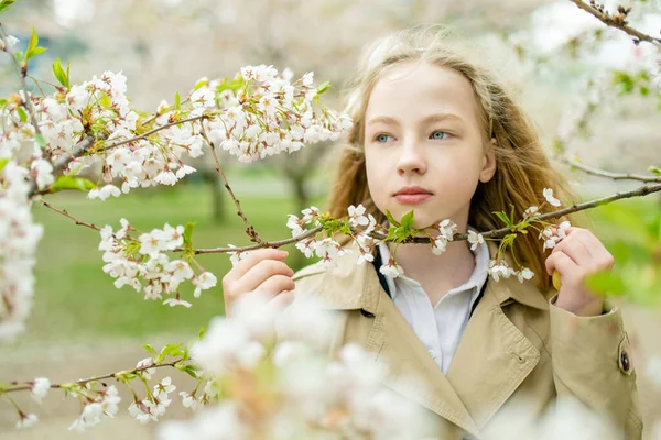 美しい春の日に桜の庭を開花中の愛らしい若い女の子 春に新鮮な桜を摘むかわいい子供 自然を探検する子供 — ストック写真