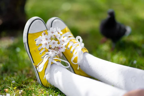 Жіночі Ноги Яскраво Жовтих Кросівках Зеленій Траві Сидить Міському Парку — стокове фото