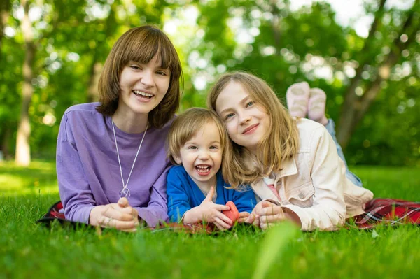 暖かい春の日に市内公園で楽しんでいる2人の姉とその弟 屋外でピクニックをしている子供たち 自然を探索する3人の子供 子供連れの家族のための積極的な屋外活動 — ストック写真