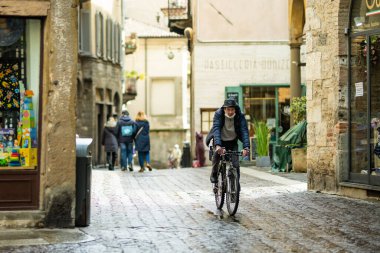 BERGAMO, İtalya - Nisan 2022: Milano 'nun kuzeydoğusundaki Bergamo şehrinin dar ortaçağ caddesi. Şehrin üst bölgesi olan Citta Alta 'nın manzarası Venedik duvarlarıyla çevrili. Bergamo, Lombardy, İtalya.