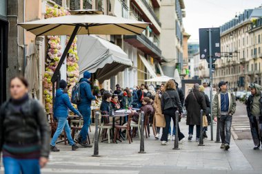 MILAN, ITALY - 2022: İtalya 'nın kuzey Lombardiya bölgesindeki bir metropol olan Milano' nun merkezinde kalabalık caddelerde yürüyen turistler ve yerliler. Milan, Lombardiya, İtalya.