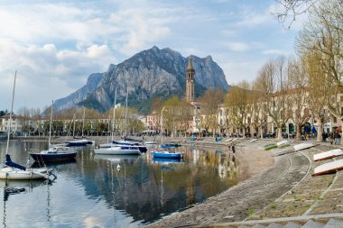 LECCO, İtalya - Nisan 2022: yatlar ve balıkçı tekneleri, Como Gölü kıyısındaki bir kasaba olan Lecco limanına yanaştı. Tipik İtalyan atmosferiyle büyüleyici bir yer. Lecco, Lombardy, İtalya.