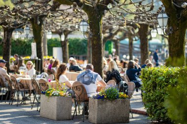 BELAGGIO, İtalya - Nisan 2022: Turistler ve yerliler, Como Gölü kıyısındaki bir kasaba olan Belaggio 'da güneşli bir bahar günü geçiriyorlar. Tipik İtalyan atmosferiyle büyüleyici bir yer. Belaggio, Lombardy, İtalya.