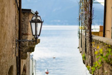 Como Gölü kıyısındaki en pitoresk kasabalardan biri olan Varenna 'daki ev duvarındaki eski fener. Tipik İtalyan atmosferiyle büyüleyici bir yer. Varenna, Lombardy, İtalya.