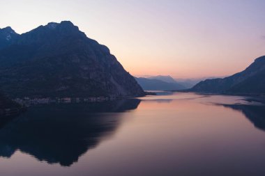Mor gün batımında ünlü Como Gölü 'nün güzel hava manzarası. Dağlar gölün sakin sularına yansıyor ve arka planda Alp dağı sıraları var. Lombardy, İtalya.