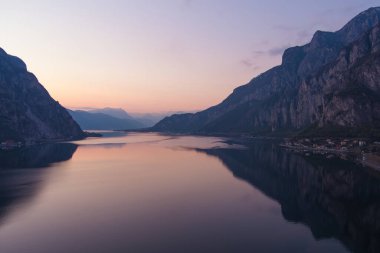 Mor gün batımında ünlü Como Gölü 'nün güzel hava manzarası. Dağlar gölün sakin sularına yansıyor ve arka planda Alp dağı sıraları var. Lombardy, İtalya.