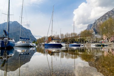 Renkli yatlar, ilkbahar günü Lecco kasabasındaki marinaya yanaşmış. Lecco 'nun ünlü Como Gölü ve manzaralı Bergamo Alpleri arasında bulunan Picturesque rıhtımı. İtalya 'da tatil beldesi.