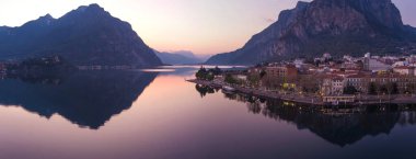 İlkbahar akşamı Lecco kasabasının çarpıcı hava manzarası. Lecco kasabasının ünlü Como Gölü ve Bergamo Alpleri arasında bulunan Picturesque rıhtımı. İtalya 'da tatil beldesi.