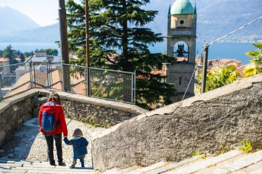 Anne ve küçük oğlu, Lecco ilinin Como Gölü 'nün doğu kıyısında Bellano kasabasını keşfediyor. Bellano, Lombardy, İtalya.