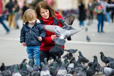 Genç anne ve küçük oğlu İtalya 'nın başkenti Milan' daki Katedral Meydanı veya Piazza del Duomo 'da güvercinleri besliyor..
