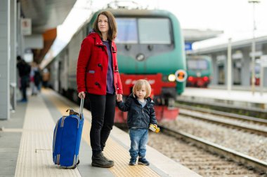 Genç anne ve küçük oğlu bir tren istasyonunda. Anne ve küçük çocuk platformda tren bekliyor. Valizli bir aile yola çıkmaya hazır. Küçük çocuklarla tatile gidiyorum..