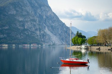 Renkli bir yat, ilkbahar günü Lecco kasabasındaki marinaya yanaşmış. Lecco 'nun ünlü Como Gölü ve manzaralı Bergamo Alpleri arasında bulunan Picturesque rıhtımı. İtalya 'da tatil beldesi.