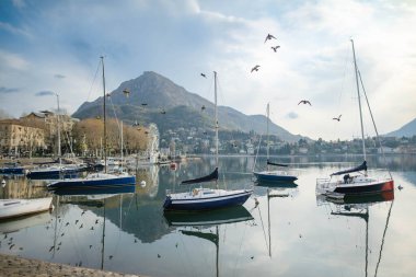 Renkli yatlar, ilkbahar günü Lecco kasabasındaki marinaya yanaşmış. Lecco 'nun ünlü Como Gölü ve manzaralı Bergamo Alpleri arasında bulunan Picturesque rıhtımı. İtalya 'da tatil beldesi.