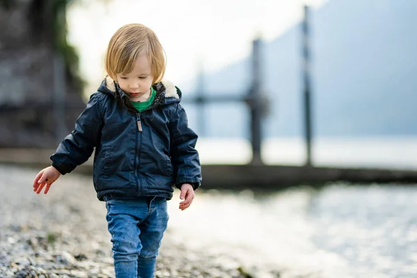 可爱的蹒跚学步的男孩在瓦伦纳港玩卵石游戏 瓦伦纳是科摩湖畔最风景秀丽的城镇之一 Varenna Lombardy 意大利 — 图库照片