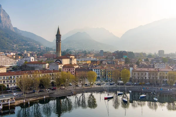 stock image Foggy aerial sunrise cityscape of Lecco town on spring day. Picturesque waterfront of Lecco town located between famous Lake Como and scenic Bergamo Alps mountains. Vacation destination in Italy.