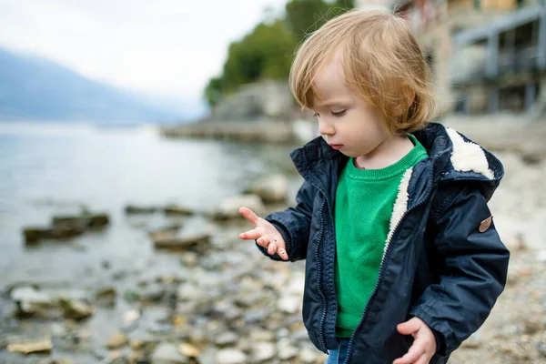 可爱的蹒跚学步的男孩在瓦伦纳港玩卵石游戏 瓦伦纳是科摩湖畔最风景秀丽的城镇之一 Varenna Lombardy 意大利 — 图库照片