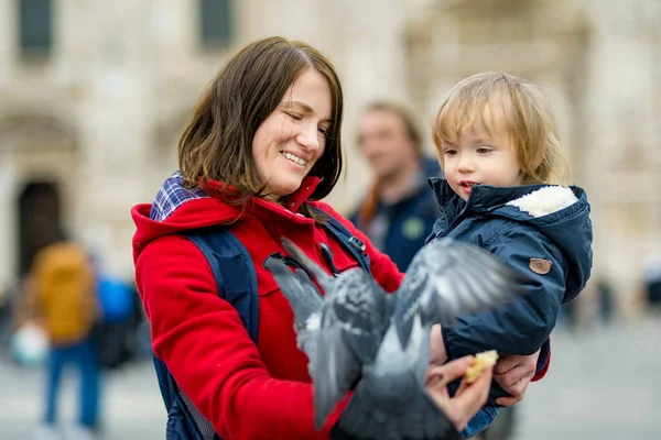 意大利伦巴第米兰市中心的大教堂广场或多摩广场上 年轻的母亲和她蹒跚学步的儿子正在喂鸽子 — 图库照片