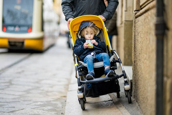年轻的父亲和他蹒跚学步的儿子坐着婴儿车在米兰市中世纪的街道上走着 去欧洲度假 — 图库照片