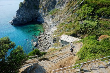 CORNIGLIA, ITALY - MAYIS 2011: 500 yıllık Cinque Terre köylerinden biri olan Corniglia 'daki kayalık plaja giden bir merdiven, İtalyan Riviera, Liguria, İtalya' nın engebeli kuzey batı kıyısında yer almaktadır..