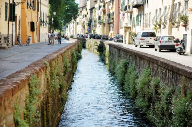 LUCCA, İtalya - Mayıs 2011: Rönesans döneminden kalma el değmemiş şehir duvarları ve iyi korunmuş tarihi merkezi ile tanınan Lucca şehrinin merkezinden akan duvarlı akarsu. Lucca ili, Toskana, İtalya.