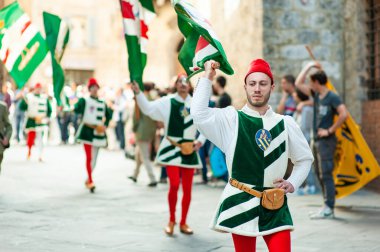 SIENA, İtalya - Temmuz 2013: Corteo Storico 'da taç giymiş bir kaz taşıyan asil Contrada dell' Oca üyeleri, İtalya 'nın Siena kentinde düzenlenen tarihi bir kostüm geçidi..