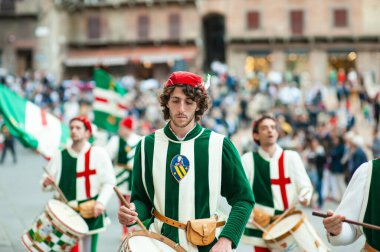 SIENA, İtalya - Temmuz 2013: Corteo Storico 'da taç giymiş bir kaz taşıyan asil Contrada dell' Oca üyeleri, İtalya 'nın Siena kentinde düzenlenen tarihi bir kostüm geçidi..