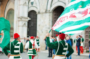 SIENA, İtalya - Temmuz 2013: Corteo Storico 'da taç giymiş bir kaz taşıyan asil Contrada dell' Oca üyeleri, İtalya 'nın Siena kentinde düzenlenen tarihi bir kostüm geçidi..
