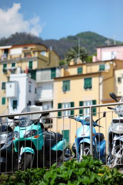 İtalyan Rivierası, Liguria, İtalya 'nın engebeli kuzeybatı kıyısındaki Cinque Terre' nin beş asırlık köylerinden biri olan Manarola 'ya parketmiş motosikletler..