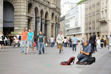 MILAN, ITALY - MAYIS 2011: İtalya 'nın kuzey Lombardiya bölgesindeki bir metropol olan Milan' ın merkezindeki işlek caddede bir sokak müzisyeni sahne alıyor. Milan, Lombardiya, İtalya.