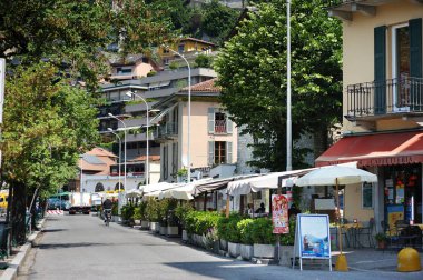 COMO, İtalya - Mayıs 2011: Como Gölü kıyısındaki Como kasabasında güneşli bir bahar günü geçiren turistler ve yerel halk. Tipik İtalyan atmosferiyle büyüleyici bir yer. Como, Lombardy, İtalya.