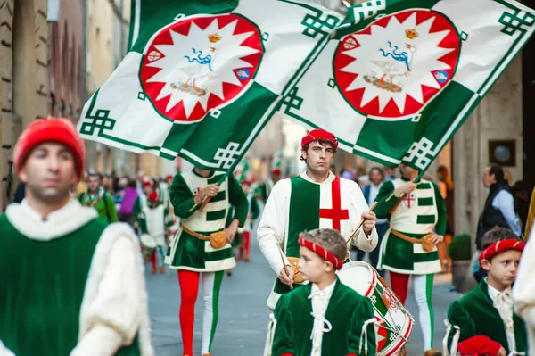 stock image SIENA, ITALY - JULY 2013: Members of the noble Contrada dell'Oca carrying flags with a crowned goose on the Corteo Storico, a historical costume parade in Siena, Tuscany, Italy.