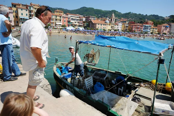 イタリアのサンテレンゾ 5月2011 観光客や地元の人々は サンテレンゾ村の港にドッキング機器を備えた小さな漁船で漁師を見ています スペツィア湾 リグーリア州 イタリア ヨーロッパ — ストック写真