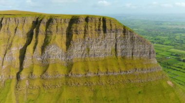 Benbulbin 'in havadan görünüşü, diğer adıyla Benbulben veya Ben Bulben, simgesel simge, büyük düz uçlu nunatak kaya oluşumu. Wild Atlantic Way, County Sligo, İrlanda 'daki muhteşem kostüm sürüş rotası.