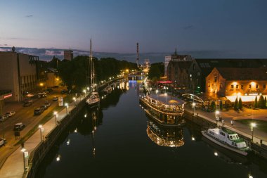 KLAIPEDA, LITHUANIA - Haziran 2022: Litvanya 'nın eski Klaipeda kentinin gece manzarası. Klaipeda liman bölgesi ve yaz akşamları çevresi.