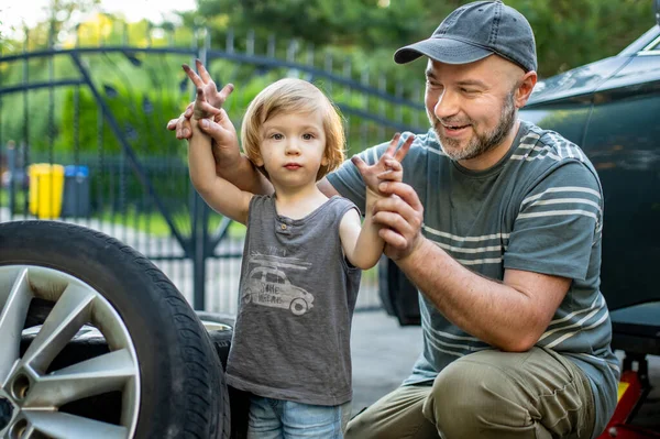 可爱的蹒跚学步的男孩帮助他的父亲在他们的后院更换车轮 父亲教他的小儿子使用工具 幼儿的积极父母 — 图库照片