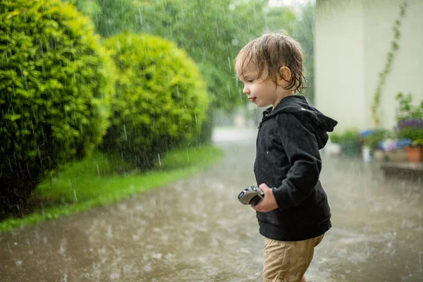 可爱的蹒跚学步的男孩在下雨天到户外玩乐 下大雨时的孩子 探索自然的孩子 — 图库照片