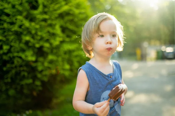 可爱的蹒跚学步的男孩在温暖的阳光明媚的夏日在户外吃美味的新鲜冰淇淋 孩子们在吃糖果 儿童不健康食品 — 图库照片