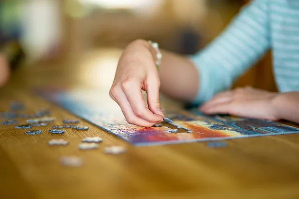 在家里密切关注妇女手玩猜谜游戏的情况 在客厅的桌子上连接拼图块 组装拼图块 家庭休闲活动 — 图库照片