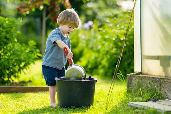 Nettes Blondes Kleinkind Das Draußen Garten Mit Einem Kochtopf Spielt — Stockfoto