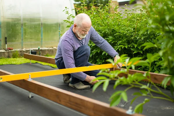 Starší Muž Pracuje Projektu Své Zahradě Muž Stavět Dřevěnou Terasu — Stock fotografie