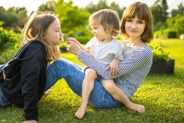 2人の姉と弟は屋外で楽しんでいます 夏の日に二人の少女が赤ん坊を抱いている 年齢差の大きい子供たち 兄弟間の大きな年齢差 大家族 — ストック写真