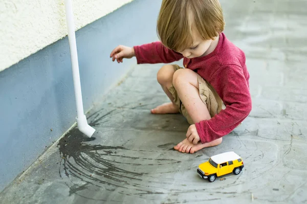 Cute Maluch Chłopiec Bawiąc Się Żółty Samochód Zabawki Zewnątrz Dzieciak — Zdjęcie stockowe
