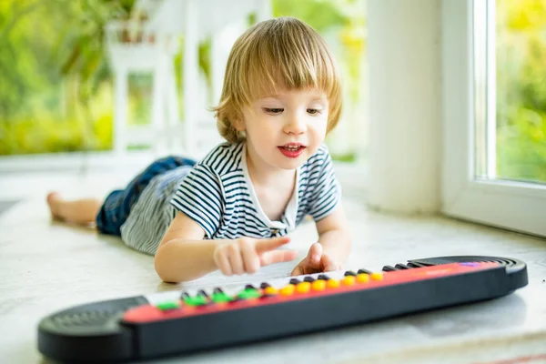 有趣的幼儿在家里弹玩具钢琴 小男孩在学弹钢琴 孩子在听音乐 幼儿的早期发育 儿童音乐教育 — 图库照片