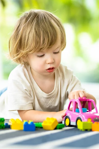 かわいい幼児の男の子が家の床にブロックの建設おもちゃをセットして遊んでいます 昼間のケア創造的な活動 おもちゃで遊んでいる子供たち 教育学習ゲーム ファミリーレジャー屋内 — ストック写真