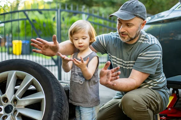 Menino Bonito Ajudando Seu Pai Mudar Rodas Carro Seu Quintal — Fotografia de Stock