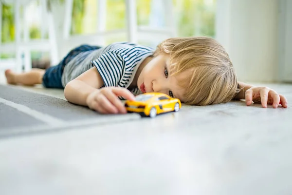Χαριτωμένο Αγοράκι Που Παίζει Κίτρινο Αυτοκινητάκι Ένα Μικρό Παιδί Διασκεδάζει — Φωτογραφία Αρχείου