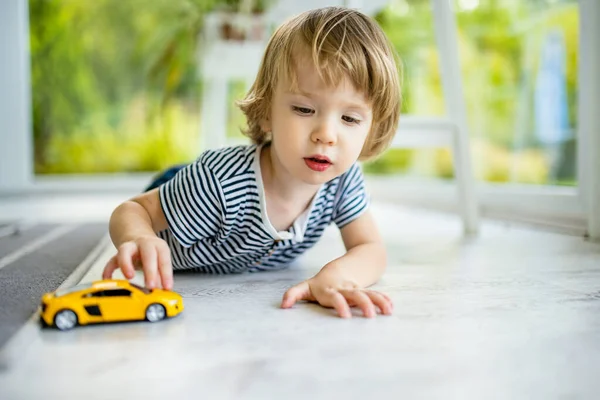 Χαριτωμένο Αγοράκι Που Παίζει Κίτρινο Αυτοκινητάκι Ένα Μικρό Παιδί Διασκεδάζει — Φωτογραφία Αρχείου
