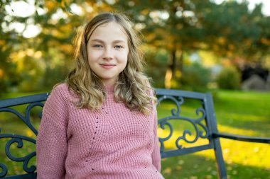 Sevimli genç kız güzel bir yaz gününde eğleniyor. Yaz parkında genç portresi. Açık havada genç bir kız.