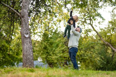 Tatlı çocuk yaz günü elma bahçesinde elma toplamaya yardım ediyor. Çocuk bahçede meyve topluyor. Çocuklar için taze sağlıklı yiyecekler. Yaz aylarında aile beslenmesi.